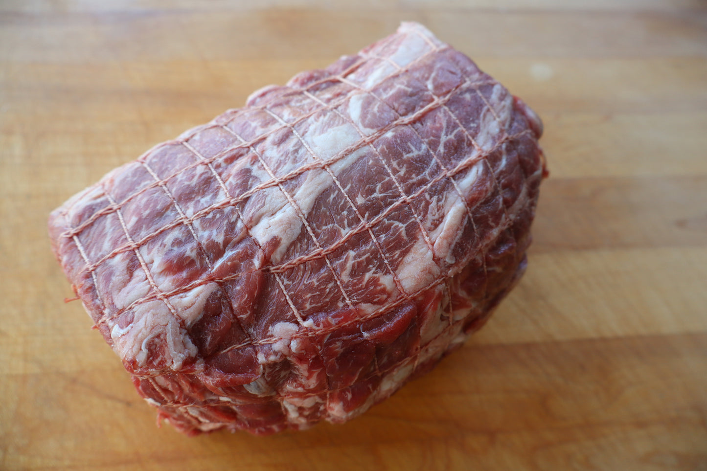 Raw beef roast chuck on a wooden cutting board