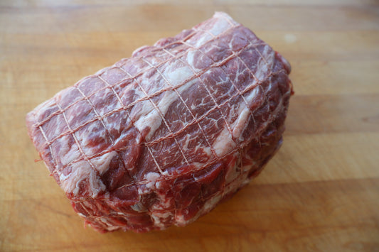 Raw beef roast chuck on a wooden cutting board