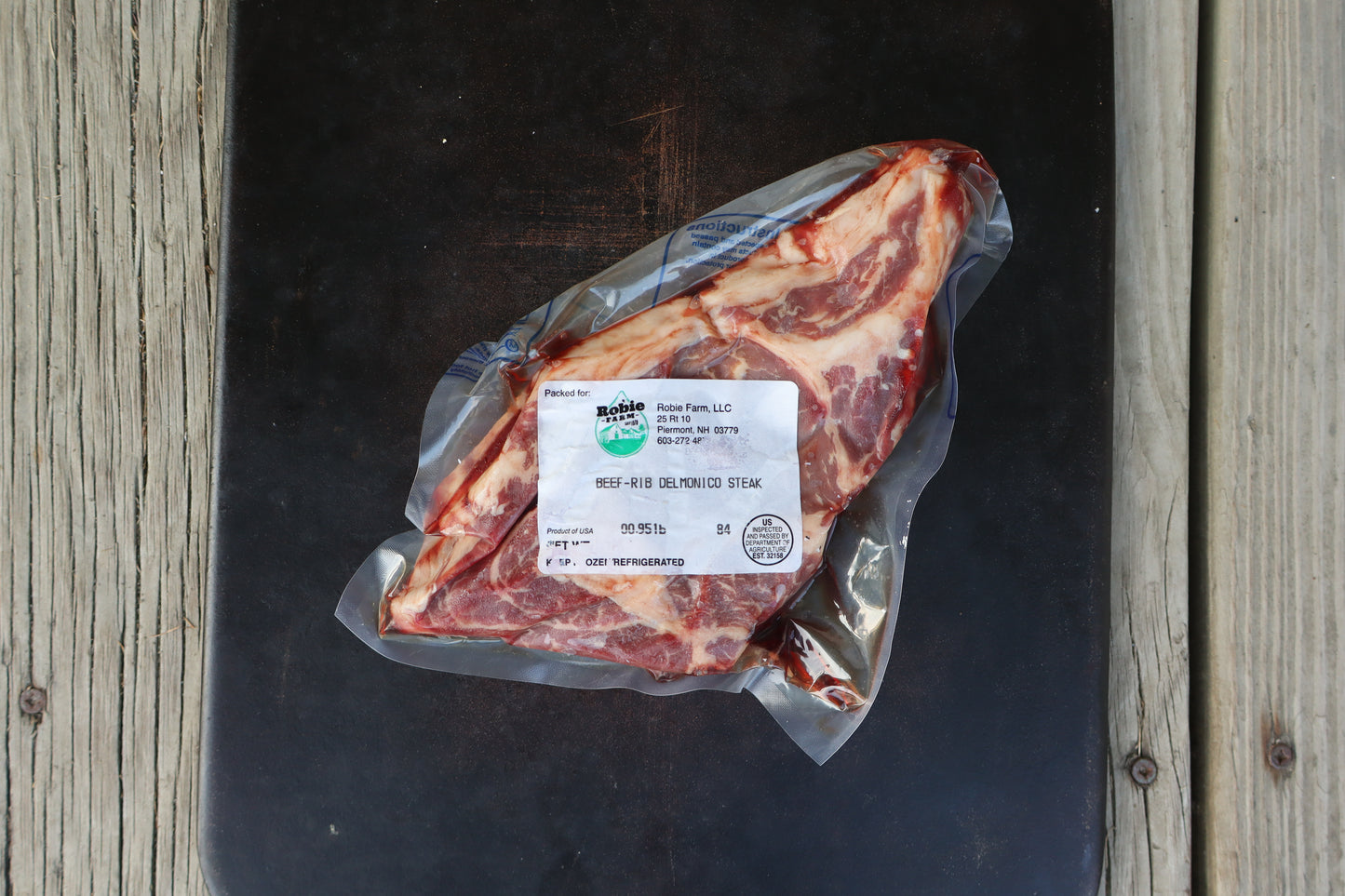 Birdseye view of a vacuum-sealed raw and marbled ribeye steak