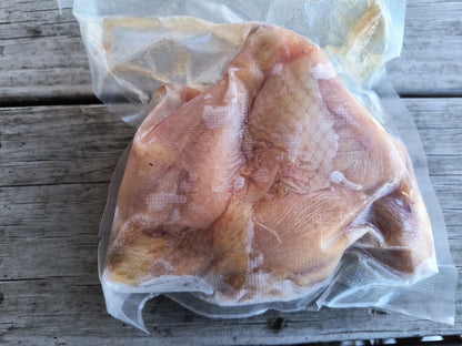 Photograph of the backside of frozen package of pasture raised Robie Farm chicken drumsticks