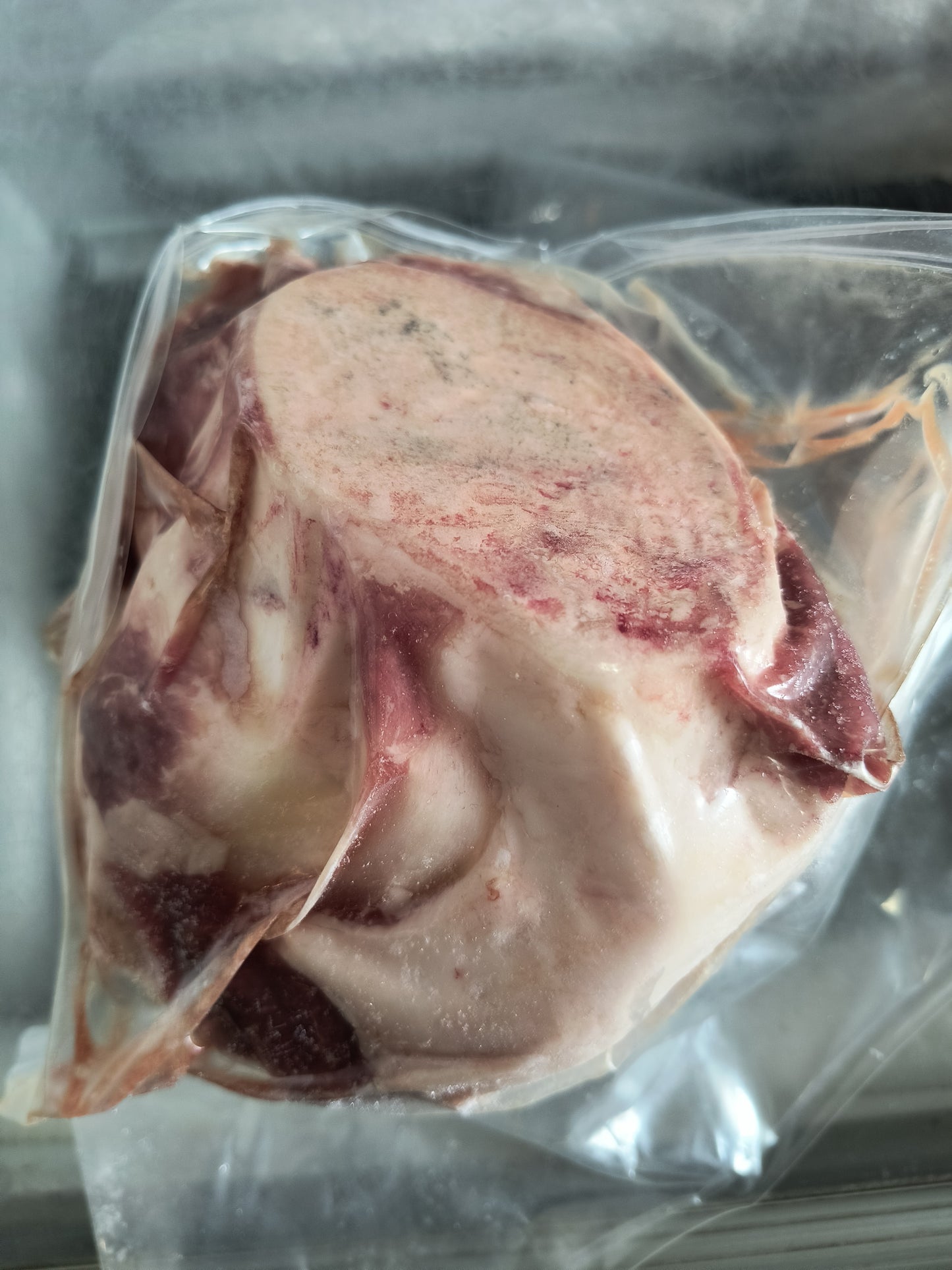 The backside of a frozen package of robie farm beef knuckle bones