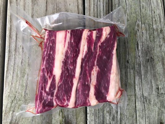 Vacuum-sealed boneless beef short ribs with visible marbling