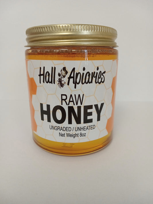 Jar of Hall Apiaries raw honey on a white background