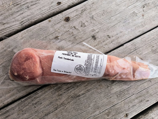 Packaged pork tenderloin on a wooden surface