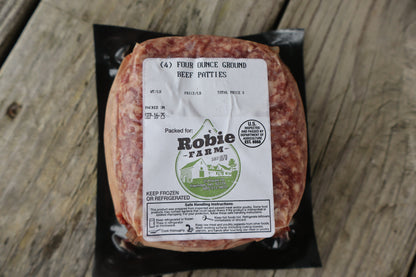 Packaged ground beef patties with a 'Robie Farm' label on a wooden surface