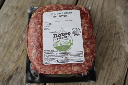 Packaged ground beef with a 'Robie Farm' label on it while it rests on a wooden surface