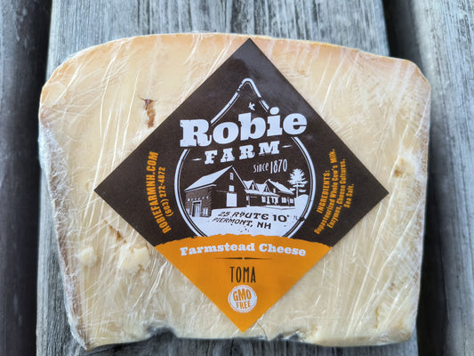 Close up image of Robie Farm Toma cheese, an alpine style cheese made from raw milk