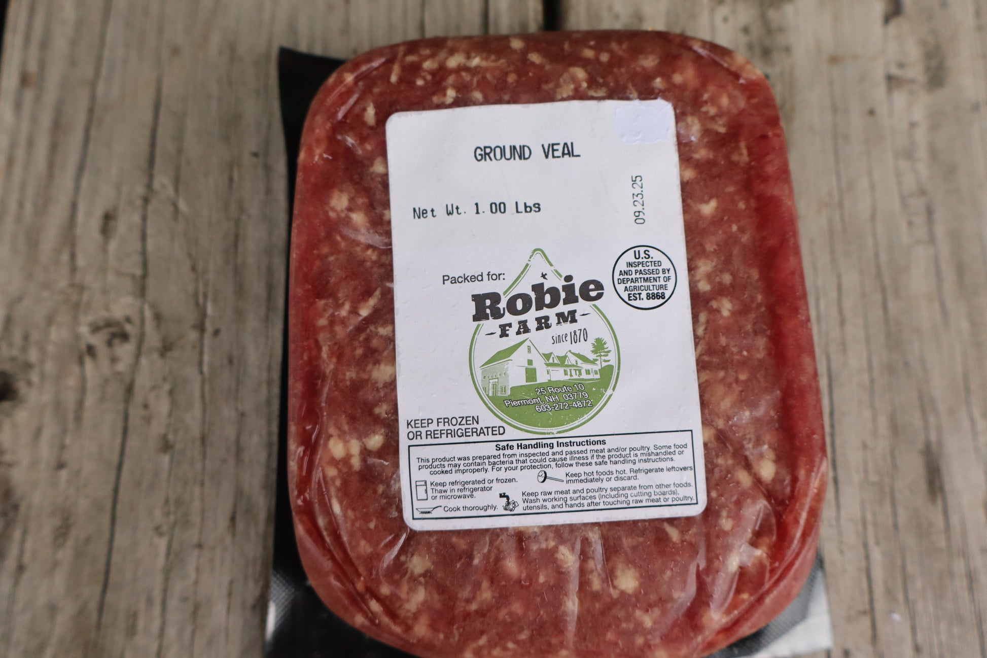Packaged ground veal from Robie Farm resting on a wooden surface