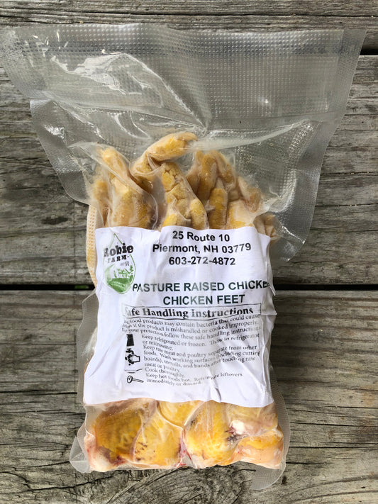 A vacuum sealed package of pastured chicken feet resting on a wooden board in Piermont NH